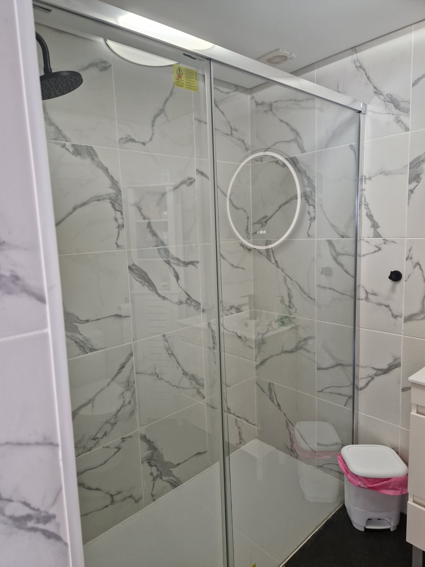 Large walk-in rainfall shower behind glass screen